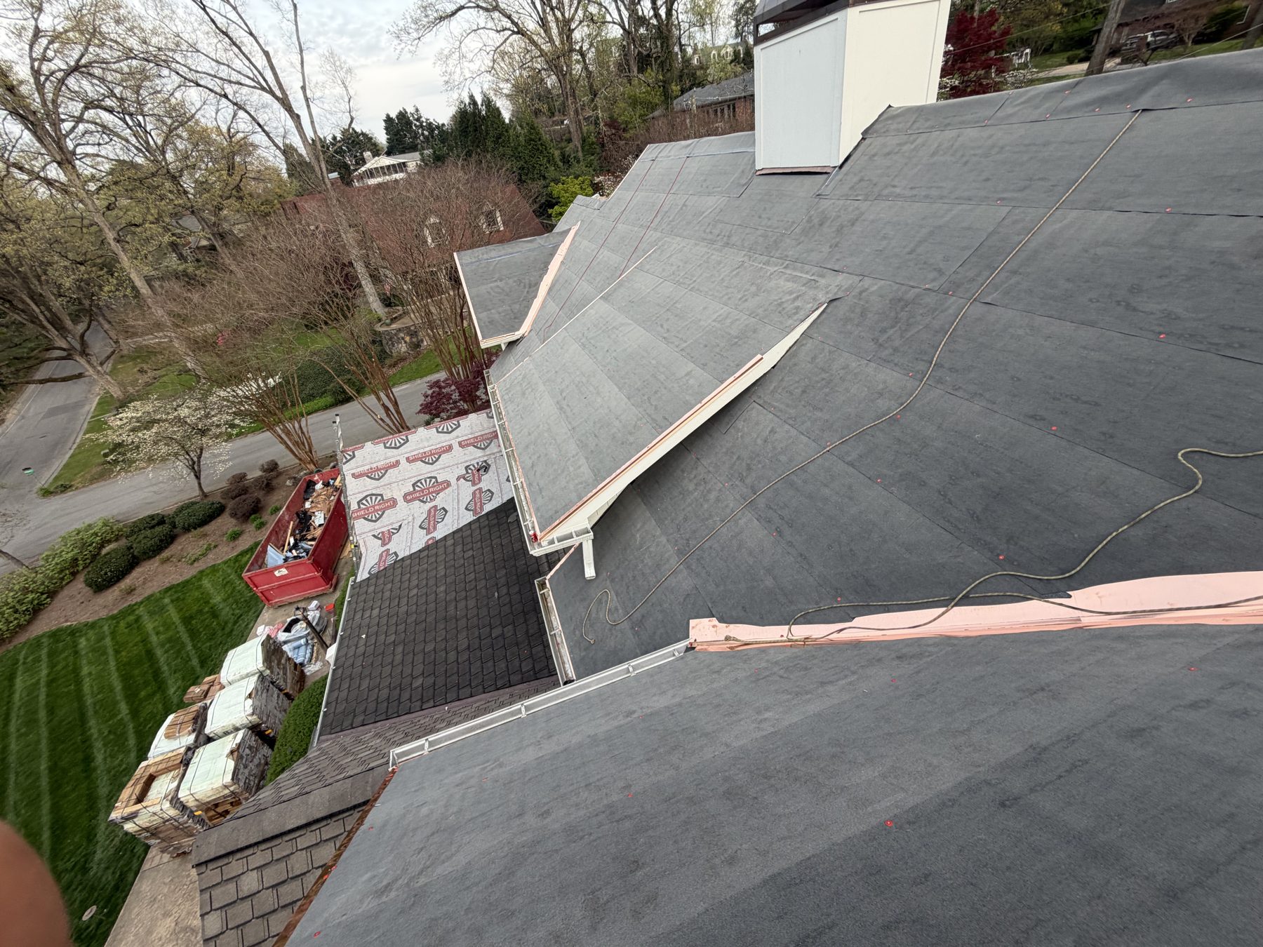 Aerial view of underlayment installation on a complex multi-slope roof