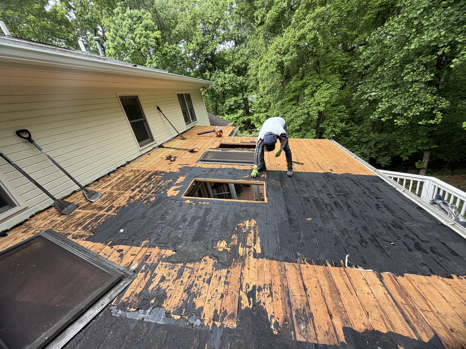 Storm-damaged roof with missing shingles and exposed decking